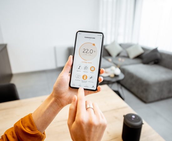 Controlling home heating temperature with a smart home, close-up Controlling home heating temperature with a smart home, close-up on phone. Concept of a smart home and mobile application for managing smart devices at home